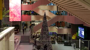 Oversikt over atriet med juledekorasjon, juletre og trapper som skiller etasjene.